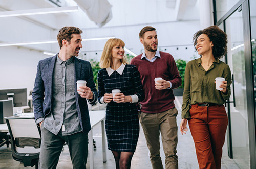 people drinking coffee and walking through the office