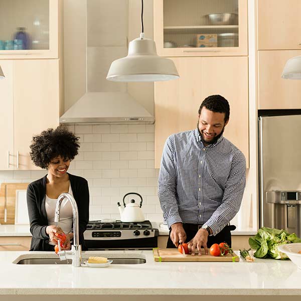 Mixed race couple cooking together in kitchen